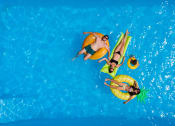 Thumbnail 5 of 11 - Sparkling pool and residents at Quarry Apartments and Townhomes in DeWitt, Michigan