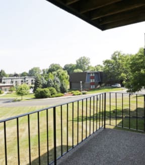 a balcony with a view of a grassy area
