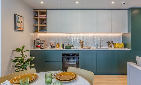 A modern kitchen with a dining table set for two.