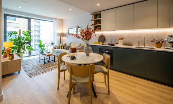 A modern kitchen with a dining table set for two.