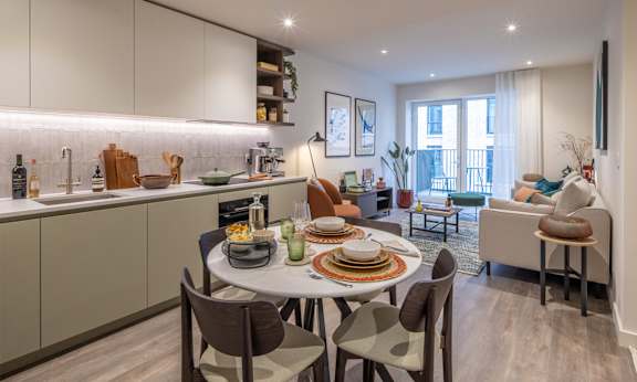 A modern kitchen with a dining table set for four.