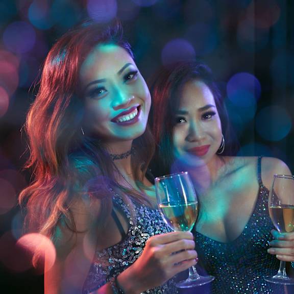 Two women holding wine glasses and smiling.