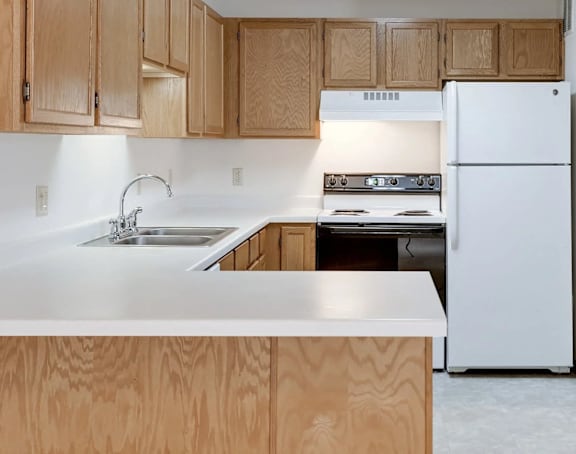 a white kitchen with stainless steel appliances and white cabinets