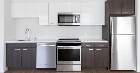 A modern kitchen with stainless steel appliances and wooden cabinets.