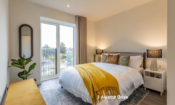 A bedroom with a large bed and a view of the outside.