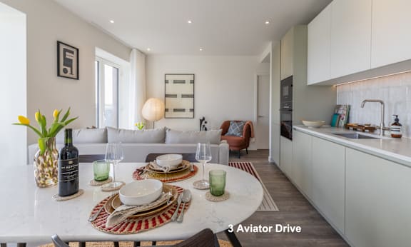 A well-lit, modern kitchen and dining area with a table set for two.
