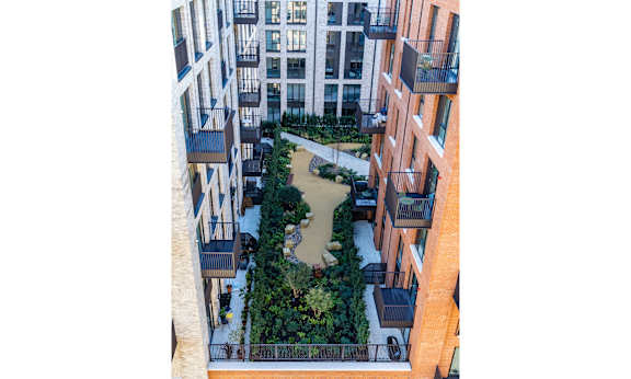 A courtyard surrounded by buildings with a fountain in the middle.