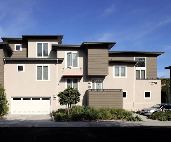 a row of tan and brown houses with a driveway