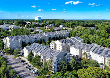 A large white building with a lot of windows and solar panels on the roof.