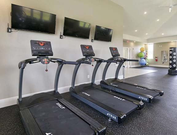 A gym with treadmills and exercise equipment at Dodson Pointe Apartment Homes, Rogers, AR, 72758
