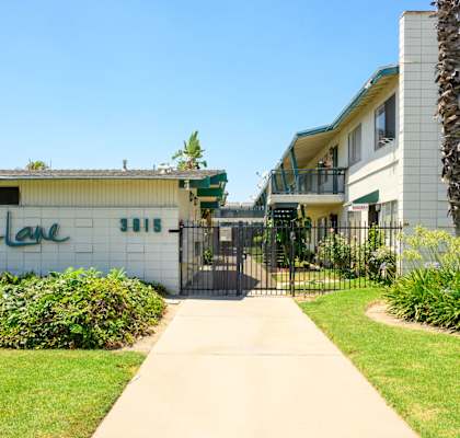 a sidewalk leads to a gated entrance to a building with a sign that reads tacoma
