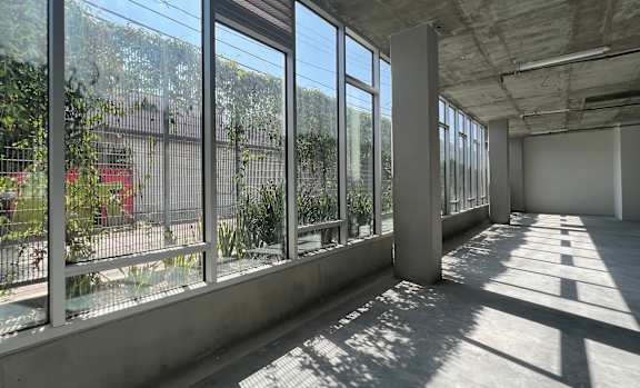 A large empty room with a lot of windows and concrete walls.