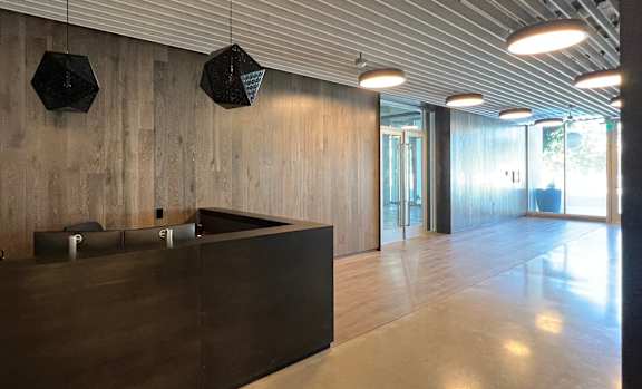 A reception area with a wooden wall and a black reception desk.