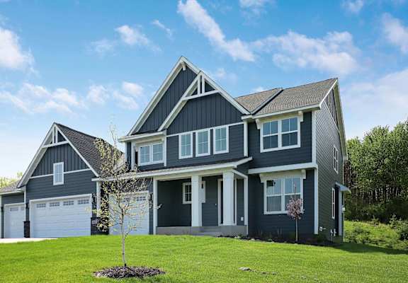 a blue house with a lawn in front of it