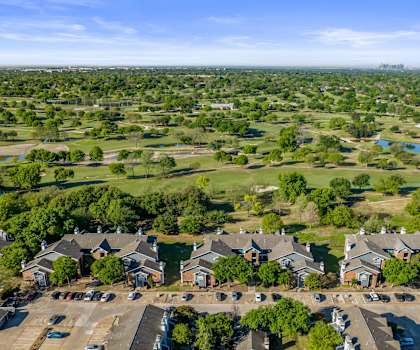 A bird's eye view of a residential area with houses and parked cars.