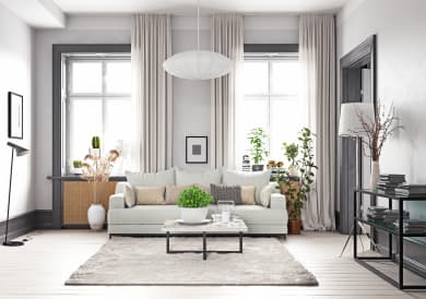 a living room with white walls and a white sofa with a coffee table in front of it