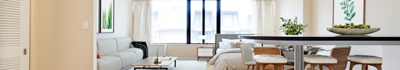 A modern living room with a dining area and a large window.