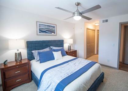 A bedroom with a bed, nightstands, and a ceiling fan. at Paces Ridge at Vinings, Atlanta, Georgia