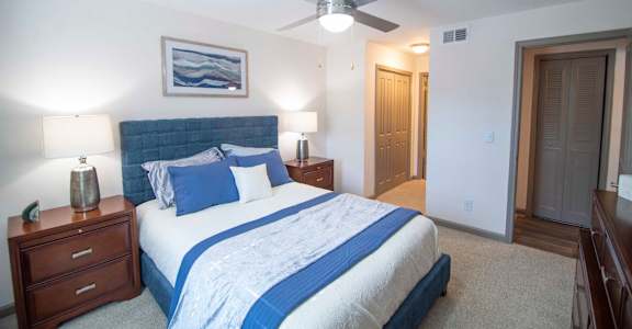 A bedroom with a bed, nightstands, and a ceiling fan.