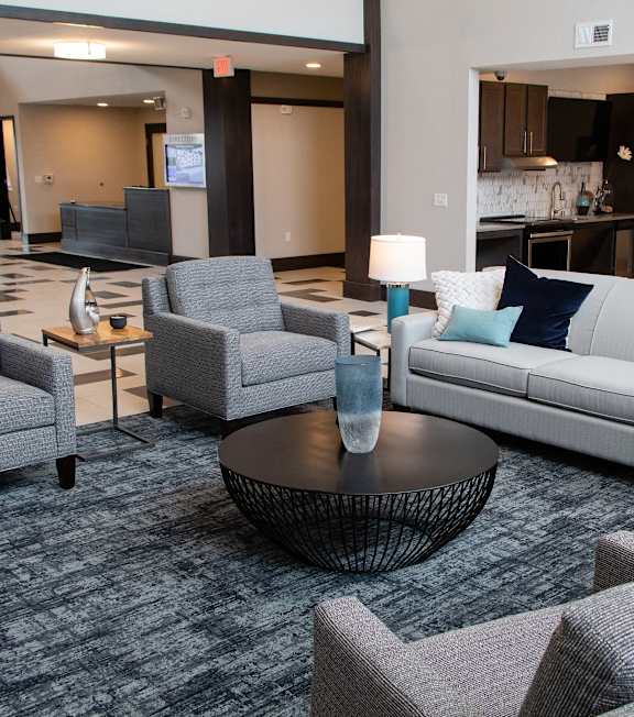 A living room with grey couches and a coffee table at Avonlea in Lakeville, MN