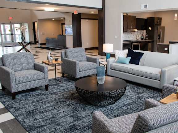 A living room with grey couches and a coffee table at Avonlea in Lakeville, MN