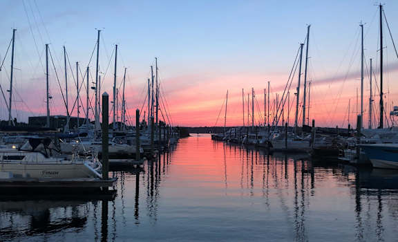 A marina filled with boats at sunset.