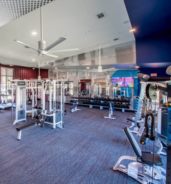 a gym with weights and cardio equipment and a sign on the wall