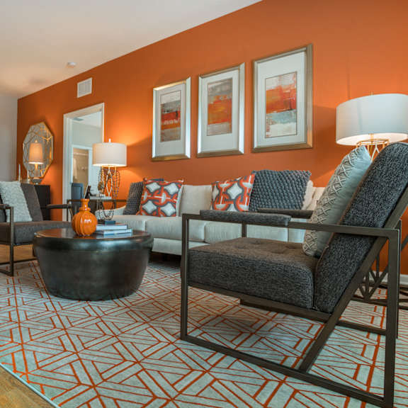 an open concept living room and dining area with a white dining table and rattan chairs