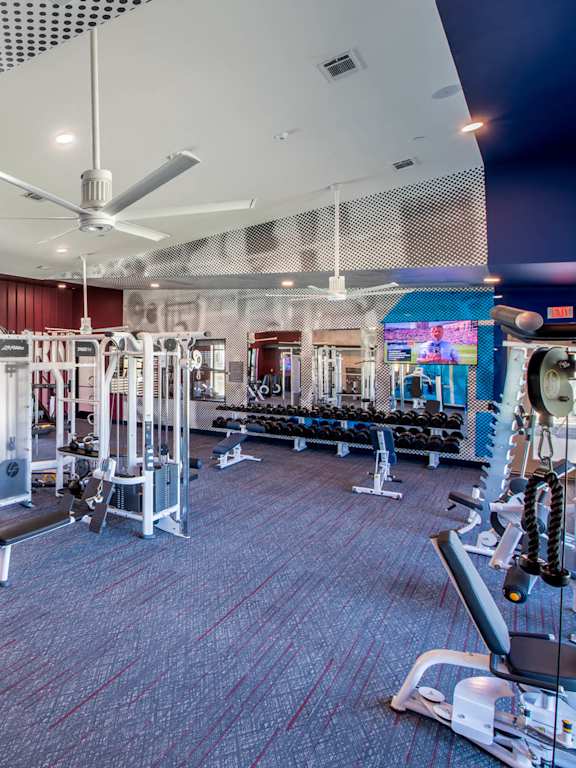a gym with weights and cardio equipment and a sign on the wall
