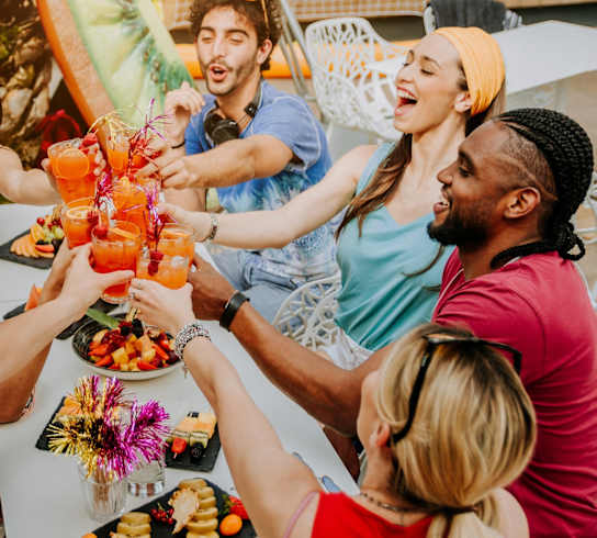 A group of people toasting with drinks at a table.