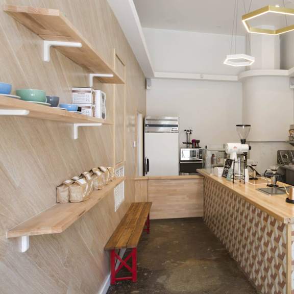A coffee shop with a wooden counter and a variety of coffee machines.