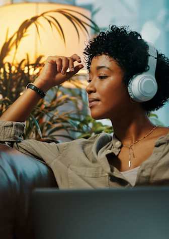 A person is sitting on a couch with headphones on.