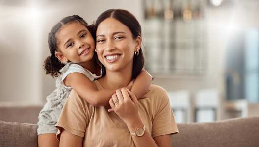 a mother and daughter sitting on a couch