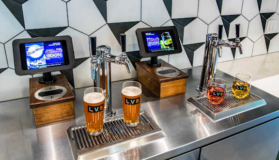 a bar with glasses of beer on a stainless steel counter