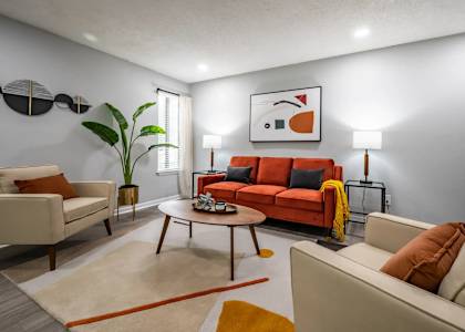 A living room with a red couch and a coffee table.
