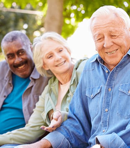 A group of people sitting outdoors on a sunny day.