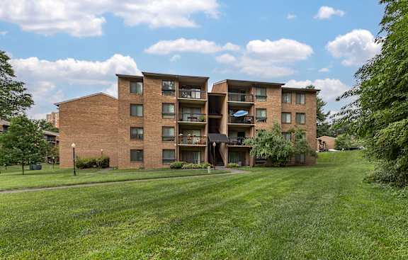 A large apartment complex with a grassy lawn in front.