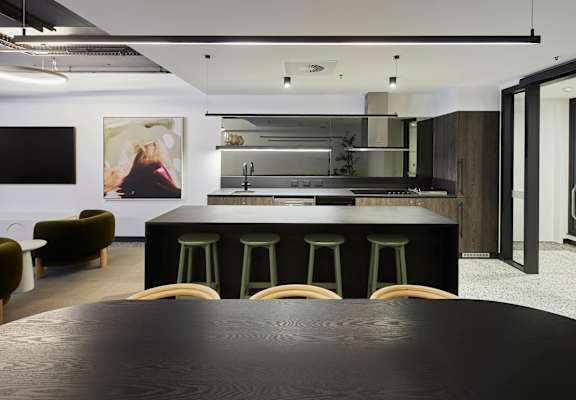 a large black kitchen with a table and chairs