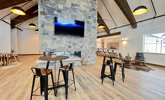 A modern living room with a stone fireplace and wooden floors at Silverbrook Apartments Apartments, Kalispell