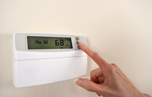 Person using the AC electronic thermostat