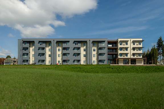 A modern building with a parking lot in front of it.