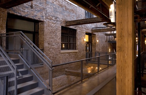 the interior of a building with stairs and a brick wall