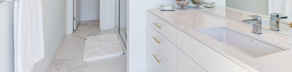 a white bathroom with a sink and a shower
