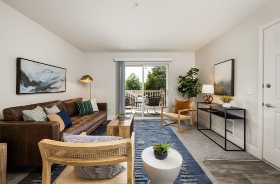 a living room with white walls and a sliding glass door that leads to a patio