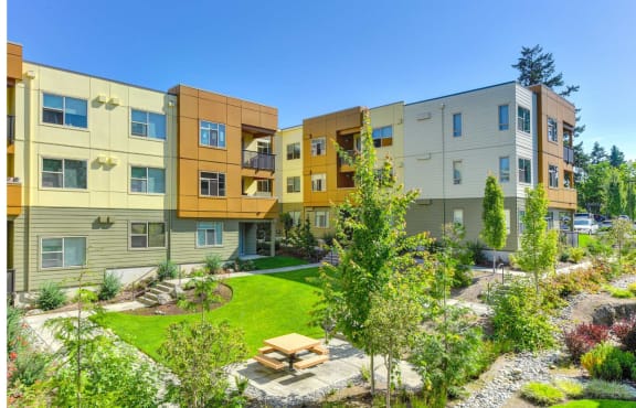 a courtyard with a picnic table in front of an apartment building