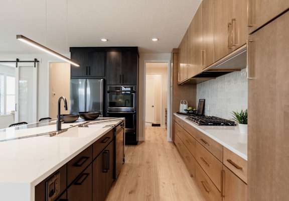 a large kitchen with wooden cabinets and white counter tops