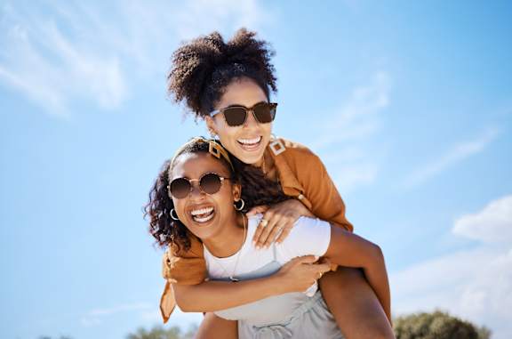 Two people are enjoying a piggyback ride outdoors.