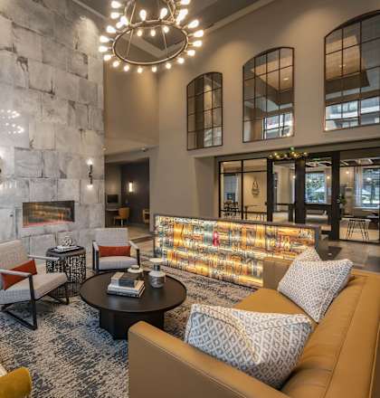 A modern living room with a stone fireplace and a large sectional sofa.