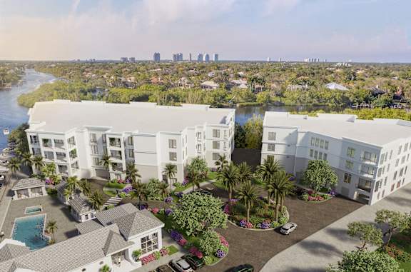 A modern apartment complex with a pool and palm trees in the foreground.