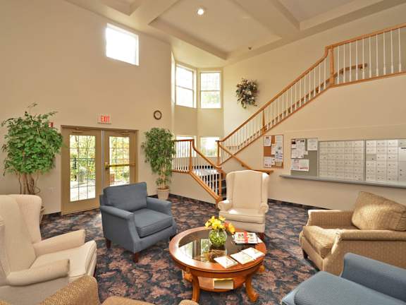 A living room with a staircase and a calendar on the wall.